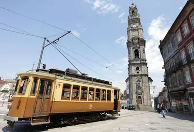 a trolley car in front of a tall tower at Oporto Hideaway 3 - Poveiros Square Balcony in Porto