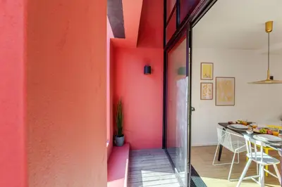 a room with a pink wall and a table at Stylish Open-Plan Flat with Swimming Pool by HostWise in Porto