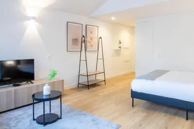 a bedroom with a bed and a tv and a table at Caldeireiros 95 by LovelyStay in Porto