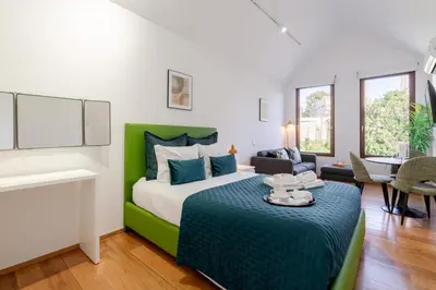 a bedroom with a green and white bed and a table at Modern & Cozy Studio by HostWise in Porto