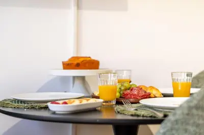 a table with plates of food and glasses of orange juice at Modern & Cozy Studio by HostWise in Porto