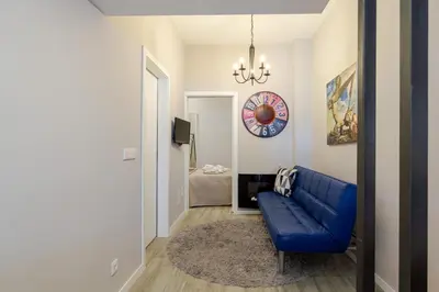 a living room with a blue couch and a clock at City Views Flats in Historic Porto by HostWise in Porto