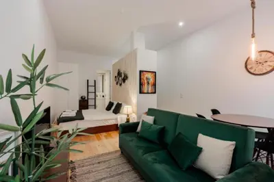 a living room with a green couch and a table at Sun Charming Apartment in Porto