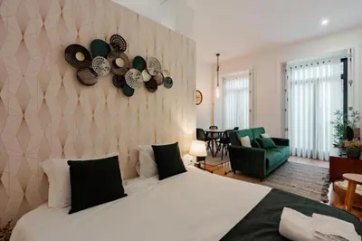 a bedroom with a large bed and a living room at Sun Charming Apartment in Porto