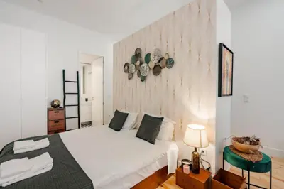 a bedroom with a white bed and a wall with plates at Sun Charming Apartment in Porto