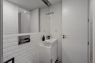 a white bathroom with a sink and a mirror at Sun Charming Apartment in Porto