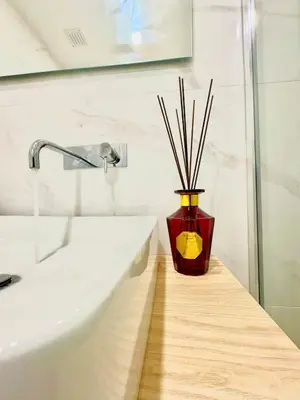 a vase with sticks in it sitting next to a sink at Douro Views by MyMoradia in Porto