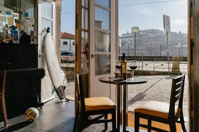 a table and chairs in a room with a window at Happy Porto Hostel in Porto