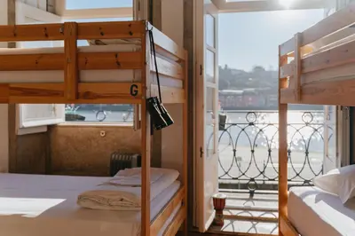 a bedroom with two bunk beds and a balcony at Happy Porto Hostel in Porto