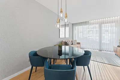 a dining room with a glass table and blue chairs at GuestReady – City Center Apartment with Balcony in Porto