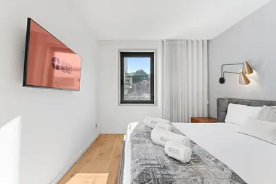 a white bedroom with a bed and a window at GuestReady – City Center Apartment with Balcony in Porto