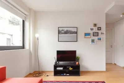 a living room with a flat screen tv on a white wall at Picaria Apartment in Porto