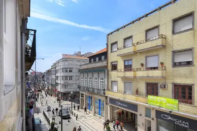 a busy city street with people walking on the street at PortoWhite city lofts in Porto