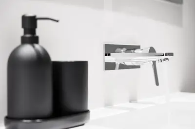 a black bottle of soap sitting on a counter at Stylish Retreat in Central Porto Stay with Parking in Porto