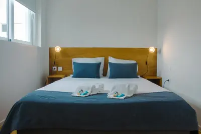 a bedroom with a bed with two towels on it at Belas Artes Apartments in Porto