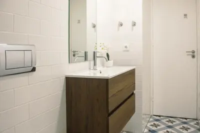 a bathroom with a sink and a mirror at Belas Artes Apartments in Porto