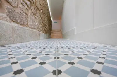 a hallway with a blue and white tiled floor at Belas Artes Apartments in Porto