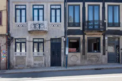 a brick building with blue doors and windows on a street at Santa Catarina Studio w Patio by LovelyStay in Porto