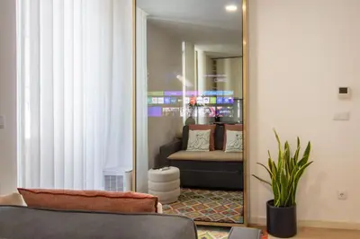 a mirror in a living room with a couch at Santa Catarina Studio w Patio by LovelyStay in Porto