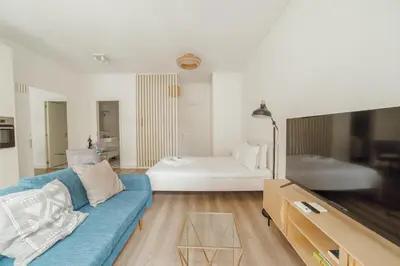 a living room with a blue couch and a bed at Downtown Comfort Apartment by Vacationy in Porto
