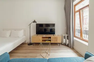 a living room with a tv and a couch at Downtown Comfort Apartment by Vacationy in Porto