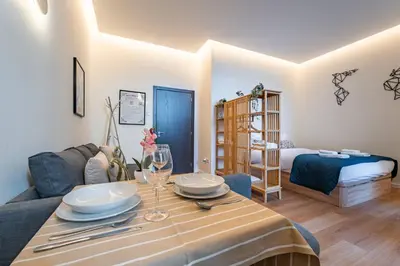 a living room with a table and a bed at Castelões Tiles Studio With Terrace in Porto