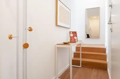 a hallway with a door and a table with a mirror at Gaia Bella Guest House in Vila Nova de Gaia