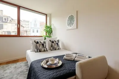 a bedroom with a bed with a tray of food on it at Modern & Bright Flat in Cedofeita by HostWise in Porto