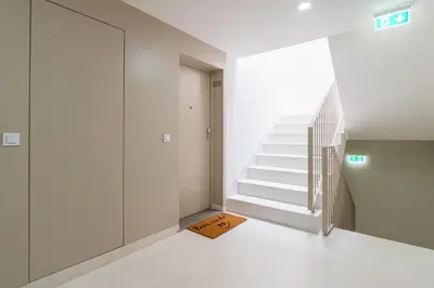 a staircase in a white room with a door and a mat at Modern & Bright Flat in Cedofeita by HostWise in Porto