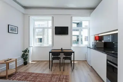 a kitchen with a table and chairs in a room at Your Base Porto Art District in Porto