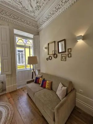 a living room with a couch and a window at Alma Porto in Porto
