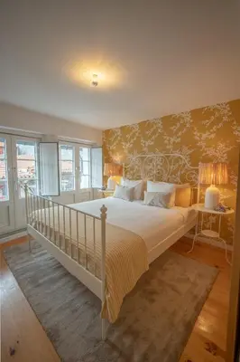 a bedroom with a large bed with a yellow wall at The Medievel in Porto