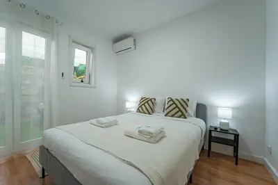 a white bedroom with a bed with two towels on it at Oporto Maria Pia Apartment Whith Terrace 2 in Porto