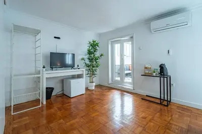 an empty living room with a hard wood floor and a tv at Oporto Maria Pia With Terrace Suite 4 in Porto