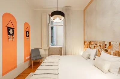 a bedroom with a large white bed and a window at VIVA Breiner Chic Apartment in Porto