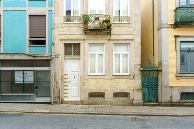 a building with white doors and windows on a street at VIVA Breiner Chic Apartment in Porto