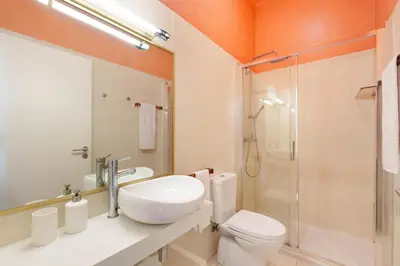 a bathroom with a toilet and a sink and a shower at VIVA Breiner Chic Apartment in Porto