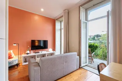 a living room with a couch and a large window at VIVA Breiner Chic Apartment in Porto
