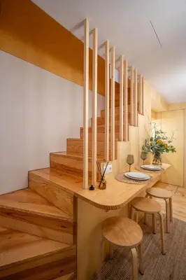 a dining room with a wooden table and wooden stairs at Belmont Riverside 5m in Porto