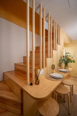 a dining room with a wooden table and wooden stairs at Belmont Riverside 5m in Porto