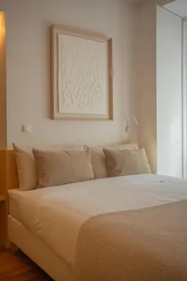 a bed in a bedroom with a picture on the wall at Belmont Riverside 5m in Porto