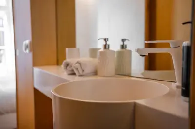 a white sink in a bathroom with a faucet at Belmont Riverside 5m in Porto