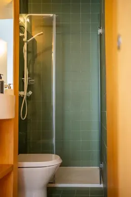 a green tiled bathroom with a shower and a toilet at Belmont Riverside 5m in Porto