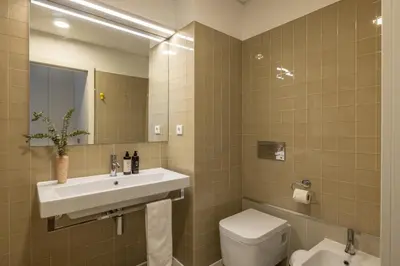 a bathroom with a sink and a toilet and a mirror at Cardosas Square Living in Porto