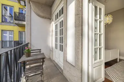 a balcony with a wooden table and a bench at Cardosas Square Living in Porto