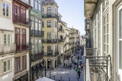 a group of people walking down a street with buildings at Cardosas Square Living in Porto
