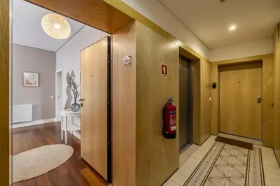 a hallway with a fire extinguisher on the door at Cardosas Square Living in Porto