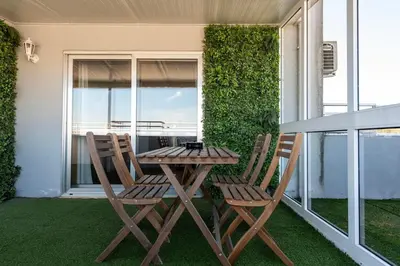 a wooden table and two chairs on a balcony at NEW! The Porto Wine Cellars Penthouse in Vila Nova de Gaia