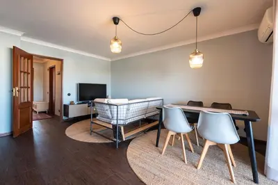 a living room with a table and chairs and a television at NEW! The Porto Wine Cellars Penthouse in Vila Nova de Gaia