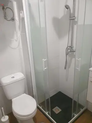 a bathroom with a toilet and a glass shower at Ribeira São Nicolau 1 in Porto